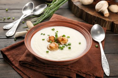 Ahşap masa üzerinde lezzetli mantar çorbası ile kase