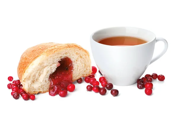 Gustoso croissant con marmellata e tazza di tè su sfondo bianco — Foto Stock