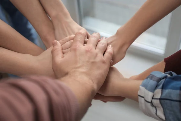 Young people putting hands together as symbol of unity, closeup — Stock Photo, Image