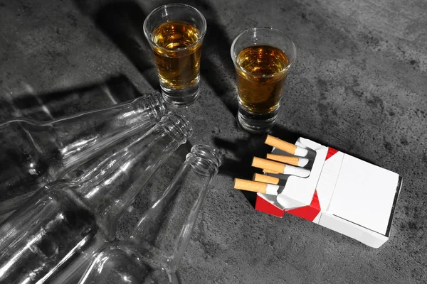 Alcohol y cigarrillos sobre fondo gris —  Fotos de Stock