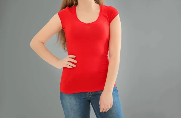 Νεαρή γυναίκα σε κομψό μπλουζάκι επάνω ελαφρύς υπόβαθρο. Κοροϊδεύω για σχεδίαση — Φωτογραφία Αρχείου