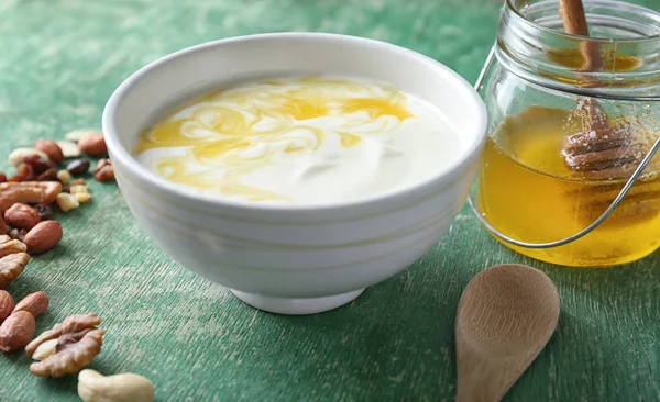 Yoghurt met honing en noten op houten tafel — Stockfoto