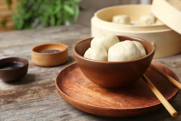 Cuenco con sabrosas albóndigas baozi en la mesa — Foto de Stock