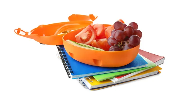 Scatola pranzo con cibo per il bambino della scuola e quaderni su sfondo bianco — Foto Stock