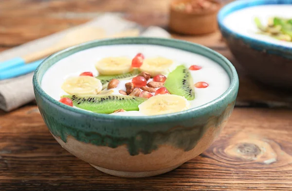 Yogurt con banana, semi di melograno e kiwi in piatto sul tavolo — Foto Stock