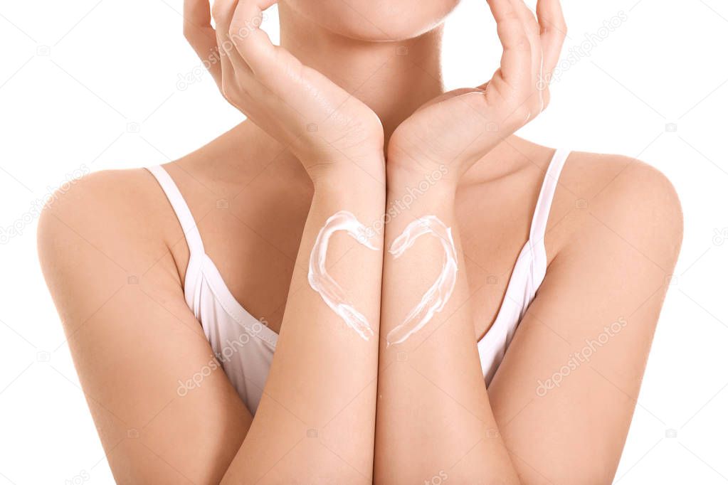 Woman with heart made of body cream on her skin against white background