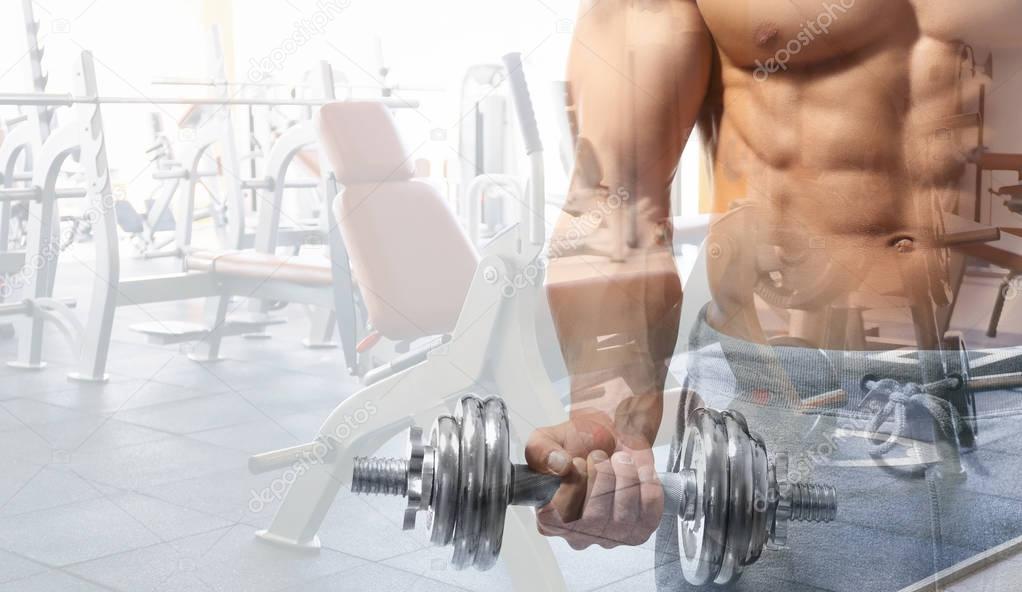 Double exposure of muscular bodybuilder with dumbbell and gym interior