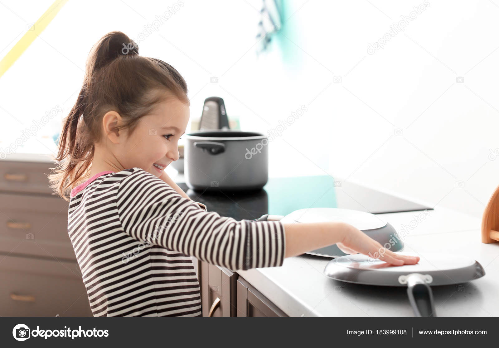 Cute little girl imagining herself DJ while playing with frying ...