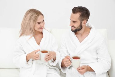 Genç çift kanepede rahatlatıcı bornoz