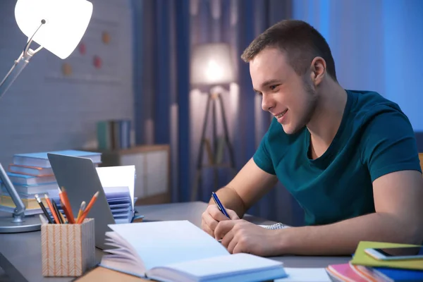 Estudiante haciendo tareas en interiores tarde en la noche — Foto de Stock