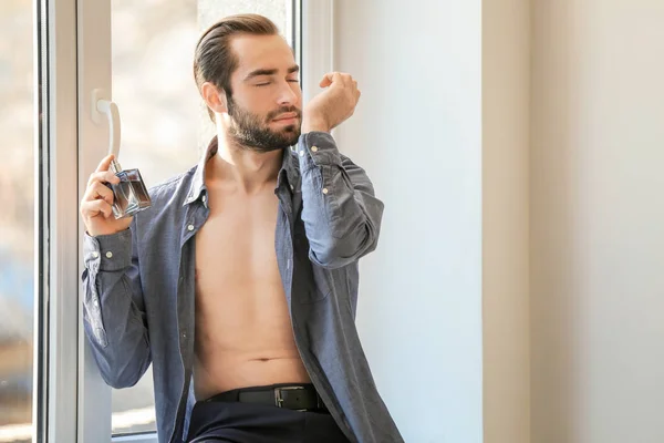 Homem bonito com garrafa de perfume — Fotografia de Stock