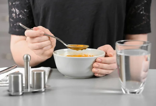 Mulher comendo saborosa sopa de lentilha na mesa — Fotografia de Stock