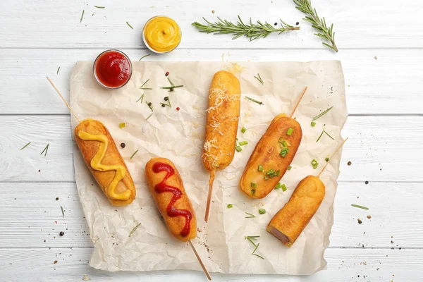 Tasty corn dogs with sauces on table — Stock Photo, Image