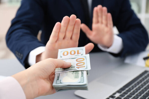 Бизнесмен отказывается брать взятки в помещении, крупным планом
