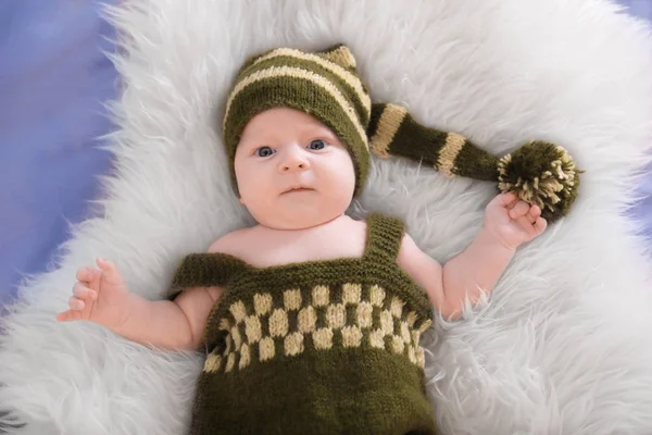 Cute little baby in elf costume lying on fur, top view — Stock Photo, Image