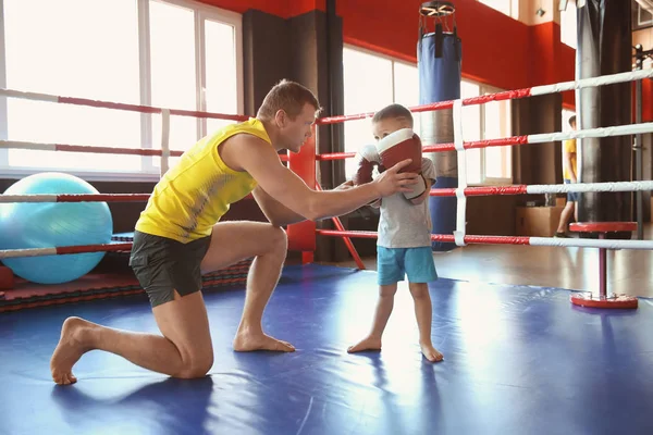 Entrenamiento de niño pequeño con entrenador en el ring de boxeo — Foto de Stock