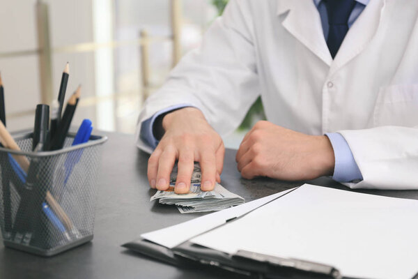 Врач со взяткой на рабочем месте
