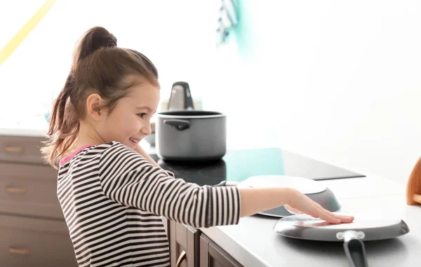 Cute little girl imagining herself DJ while playing with frying pan in kitchen — Stock Photo, Image