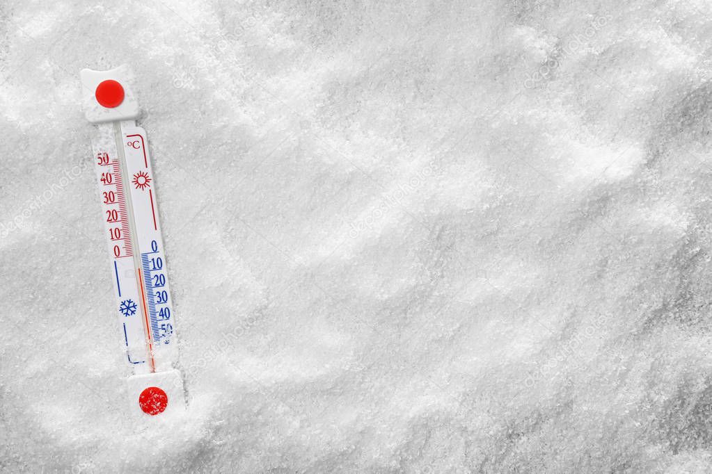 Weather thermometer lying on snow