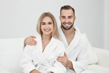 Genç çift kanepede rahatlatıcı bornoz