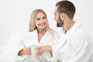 Genç çift kanepede rahatlatıcı bornoz