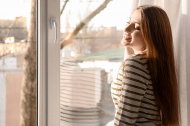 Pencere kapalı duran genç kadın