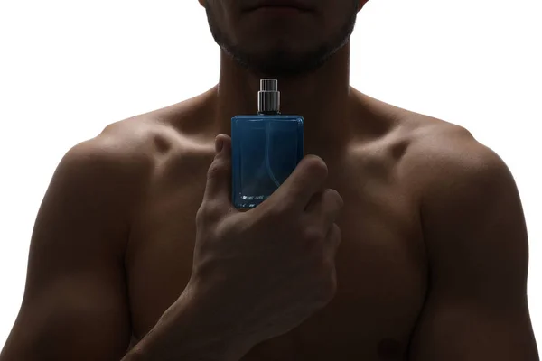 Bonito homem com garrafa de perfume no fundo branco, close-up — Fotografia de Stock