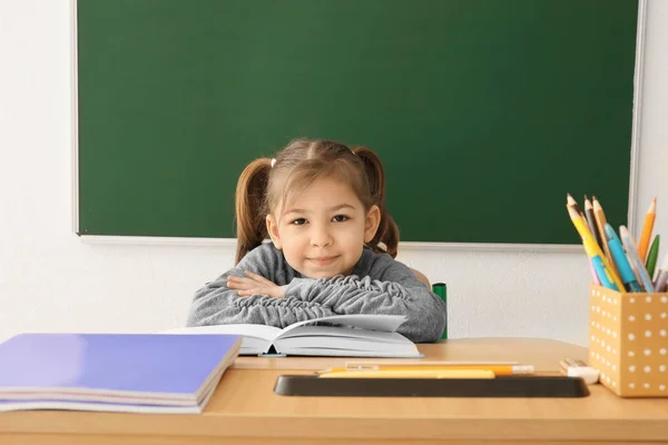 Menina bonito fazendo lição de casa em sala de aula — Fotografia de Stock