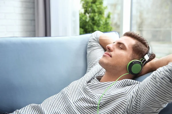 Расслабленный Молодой Человек Слушает Музыку Дома — стоковое фото