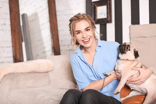 自宅のソファーにかわいいパグ犬と若い女性 ペット採用 — ストック写真