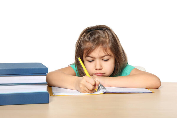 Cute little girl doing homework against white background