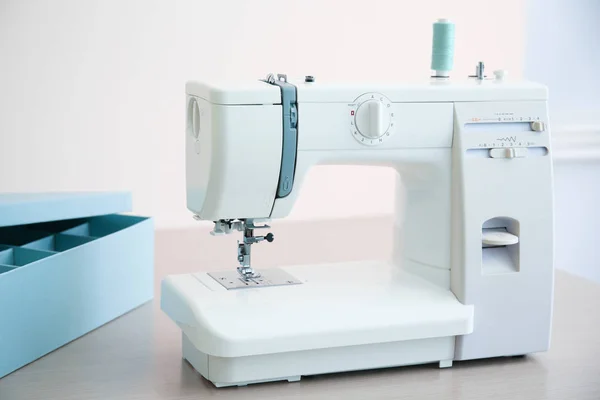 Швейная машина на столе в мастерской портного — стоковое фото