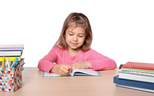 Linda niña haciendo la tarea contra el fondo blanco —  Fotos de Stock