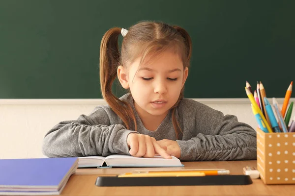 Schattig klein meisje huiswerk in klas — Stockfoto