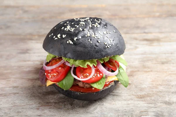 Hambúrguer saboroso com pão preto — Fotografia de Stock