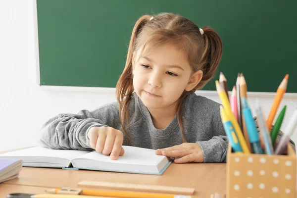 Petite fille mignonne faisant ses devoirs en classe — Photo