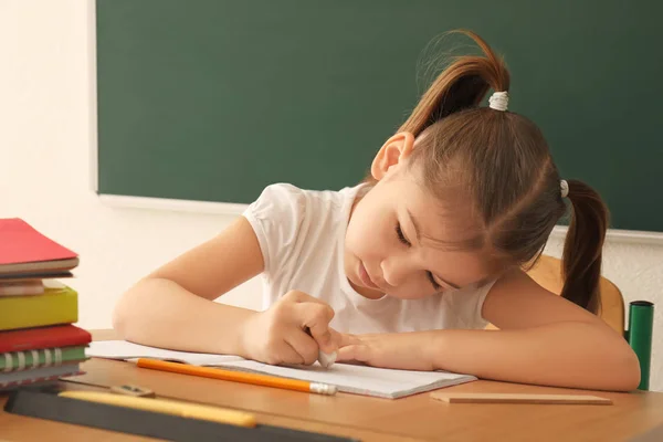 Petite fille mignonne faisant ses devoirs en classe — Photo