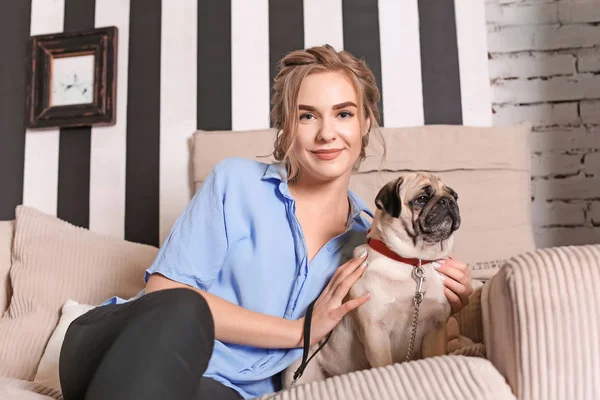 自宅のソファーにかわいいパグ犬と若い女性 ペット採用 — ストック写真