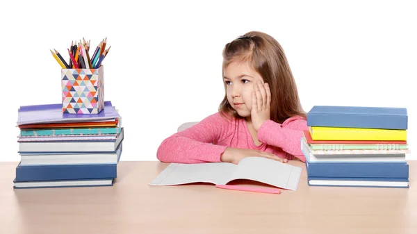 Olycklig liten flicka med massa läxor att göra mot vit bakgrund — Stockfoto