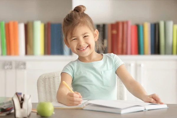 Linda niña haciendo la tarea en el interior —  Fotos de Stock