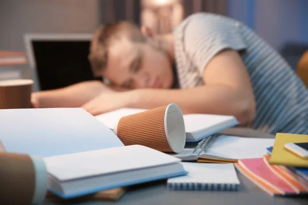 Tasse à café et étudiant endormi sur fond, gros plan — Photo