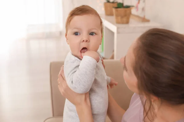 Giovane madre con il suo piccolo bambino carino sul divano di casa — Foto Stock