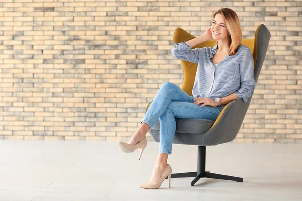 Mujer joven en sillón — Foto de Stock