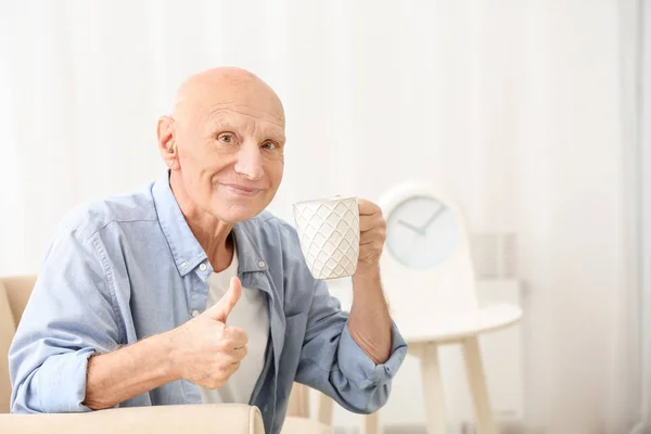 Чоловік Вадами Слуху Чашкою Чаю Показує Жест Великого Пальця Вдома — стокове фото