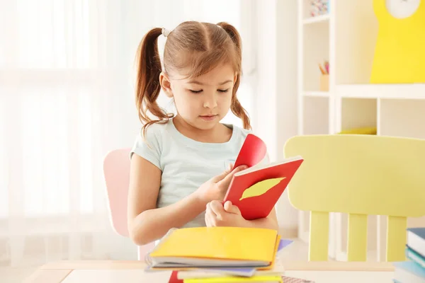 Nettes kleines Mädchen macht Hausaufgaben drinnen — Stockfoto