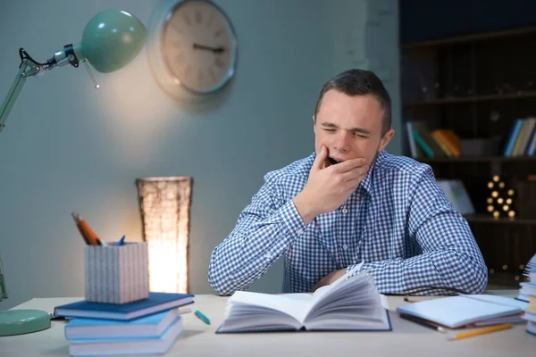 Vermoeide student binnenshuis laat op de avond huiswerk — Stockfoto