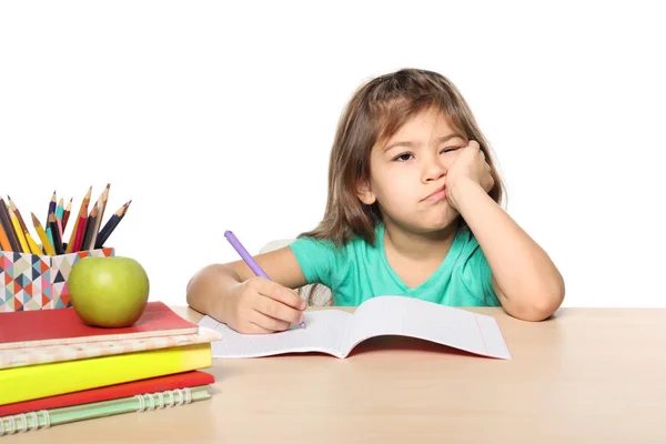 Bored little girl unwilling to do homework against white background Stock Image