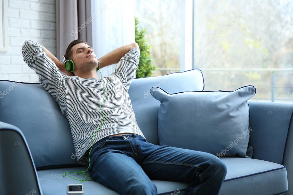 Relaxed young man listening to music at home