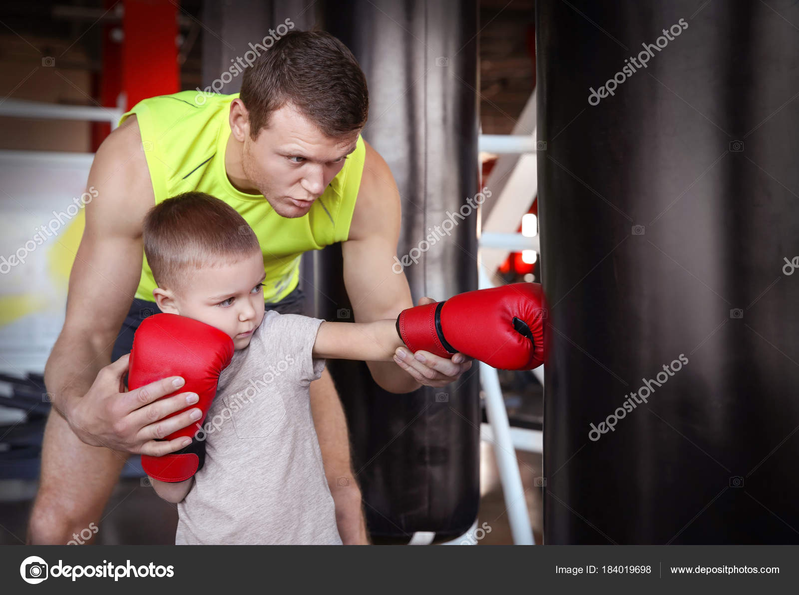 Little boy training with coach and punchbag in boxing gym — Stock Photo