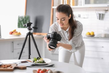 Genç kadın mutfakta natürmort fotoğraf çekmeye profesyonel kamera ile